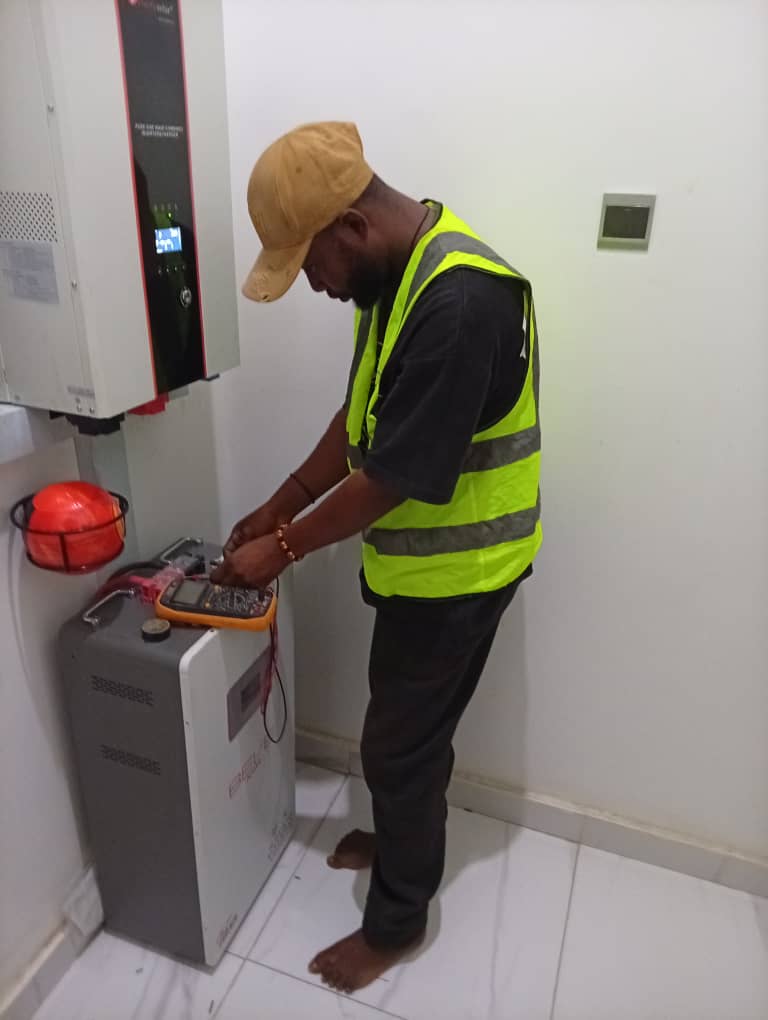 a man connecting a solar inverter and battery